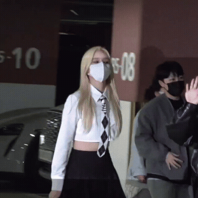 Woman Wearing Mask In Front Of Parking Garage GIF