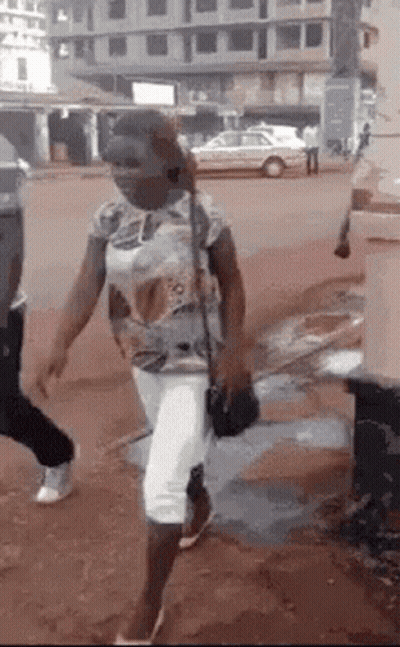 Woman Wearing Mask Walking Down Street With Purse GIF