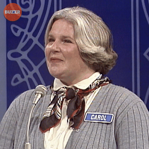 Woman Wearing Name Tag Carol In Front Of Microphone GIF