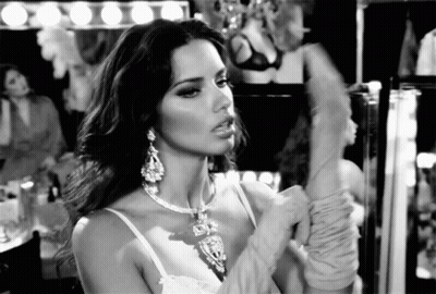 Woman Wearing Necklace and Gloves Looking in Mirror