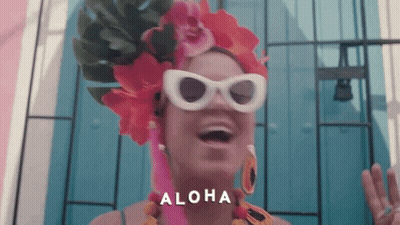 Woman Wearing Sunglasses And Flowered Headpiece Says Aloha GIF