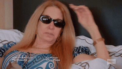 Woman Wearing Sunglasses Lying On Bed GIF