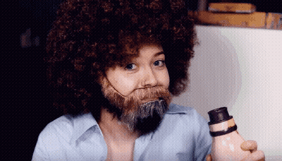Woman With Afro And Beard Holding Bottle GIF