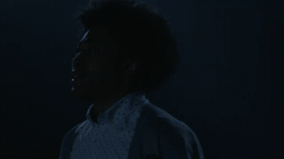 Woman With Afro Eyes Closed In Dark GIF