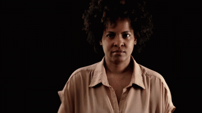 Woman With Afro In Tan Shirt GIF