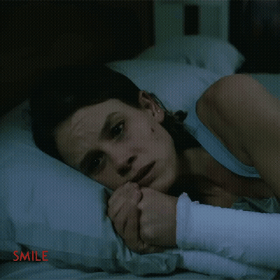 Woman With Arm Bandage Lying On Bed Smile GIF