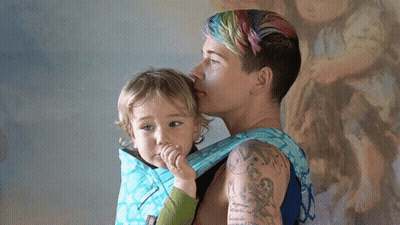 Woman With Arm Tattoo Carrying Child GIF