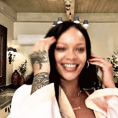 Woman With Arm Tattoo Smiling Touching Hair GIF