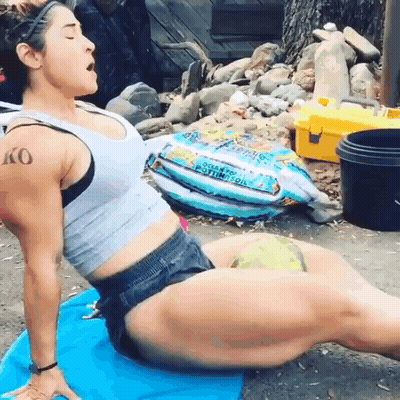 Woman With Arm Tattoo Stretching On Blue Mat GIF