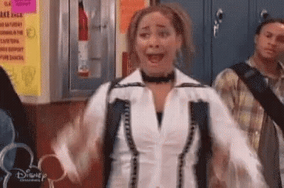 Woman With Arms Outstretched And Backpack In Hallway GIF
