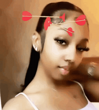 Woman With Arrows In Hair And Hearts Taking Selfie GIF