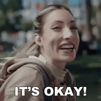 Woman With Backpack Smiling And Saying It's Okay GIF