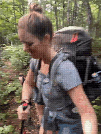Woman With Backpack Walking Through Forest GIF