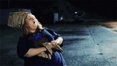 Woman With Bag On Head Standing By Road GIF