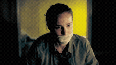 Woman With Bandage Around Mouth Looking At Camera GIF