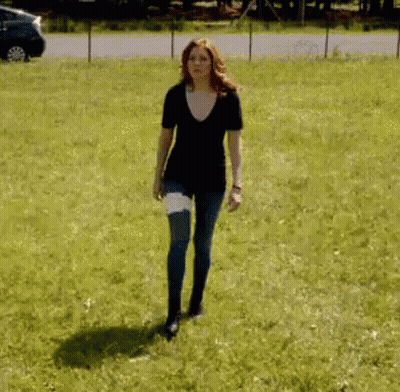 Woman With Bandage Walking In Grassy Field GIF