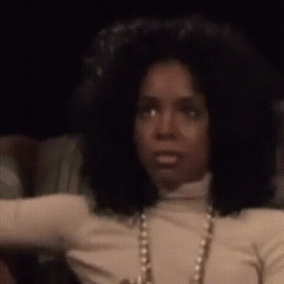 Woman With Big Afro In White Turtleneck And Pearls GIF