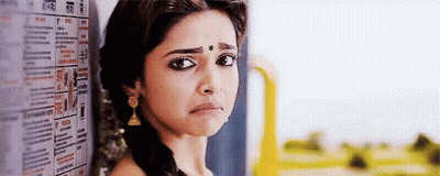 Woman With Bindi Leaning Against Wall With Newspaper GIF