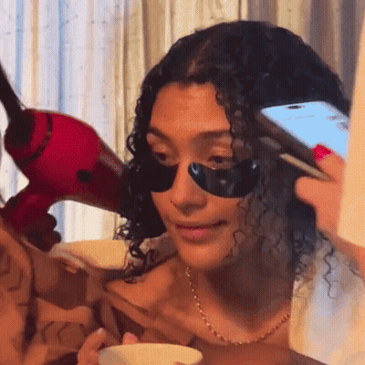 Woman With Black Eye Patches Holding Phone GIF