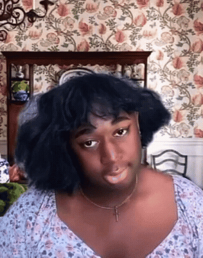 Woman With Black Hair And Necklace In Floral Wallpaper GIF