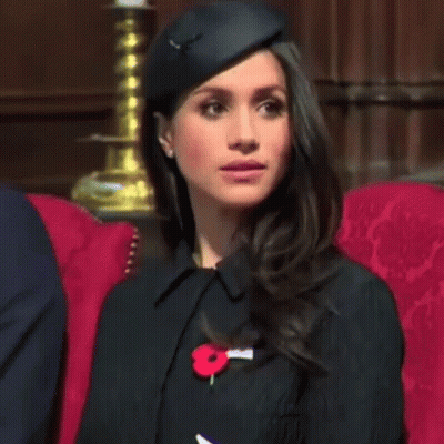 Woman With Black Hat And Red Poppy Pin In Red Chair GIF