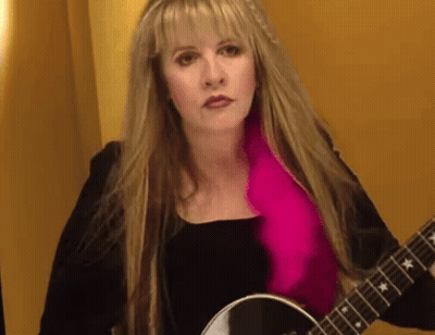 Woman With Blonde Hair And Pink Scarf Holding Guitar GIF