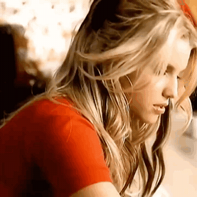 Woman With Blonde Hair And Red Shirt Looking Down GIF