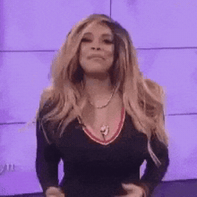 Woman With Blonde Hair, Black Top, Necklace, Purple Wall GIF