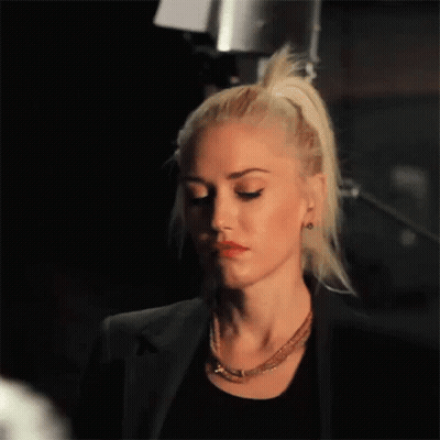 Woman With Blonde Hair In Black Jacket And Necklace GIF