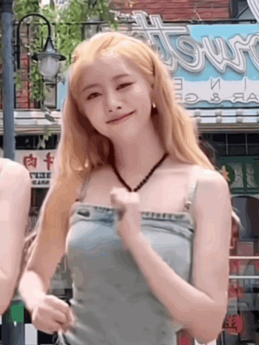 Woman With Blonde Hair In Blue Tank Top And Overalls GIF
