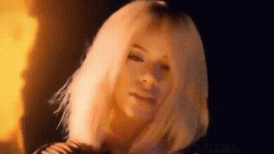 Woman With Blonde Hair In Front Of Fire GIF