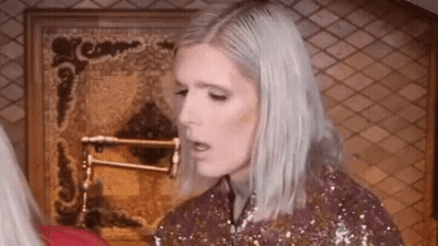 Woman With Blonde Hair In Front Of Fireplace GIF