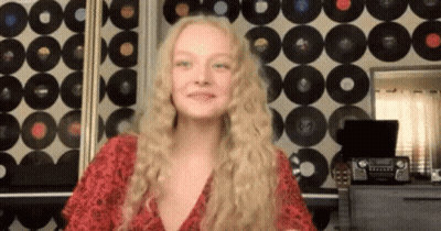 Woman With Blonde Hair In Front Of Record Wall GIF