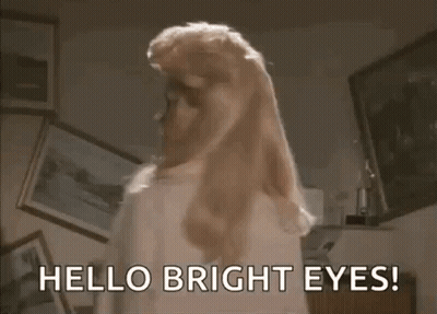 Woman With Blonde Hair Saying Hello Bright Eyes GIF