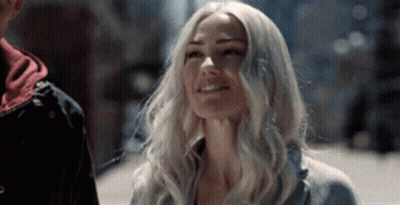 Woman With Blonde Hair Standing Next To Man On City Street GIF