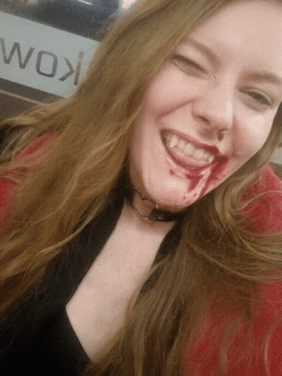 Woman With Blood Smiling In Front Of Wok Sign GIF