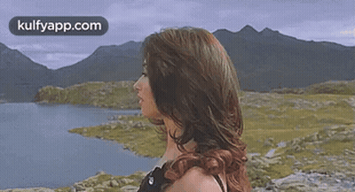Woman With Blowing Hair By Lake And Mountains GIF