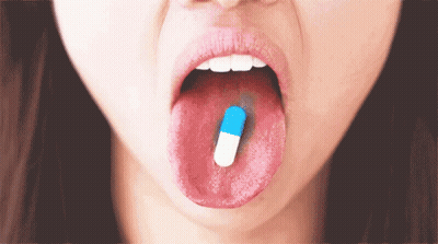 Woman With Blue And White Capsule In Mouth GIF