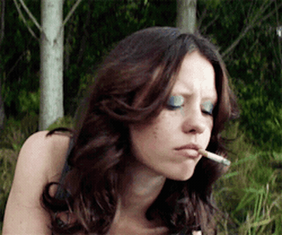 Woman With Blue Eyeshadow Smoking Cigarette In Woods GIF