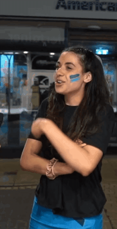 Woman With Blue Face Paint In Front Of American Airlines GIF