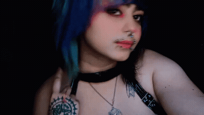 Woman With Blue Hair And Piercings Taking Selfie With Bat Necklace GIF