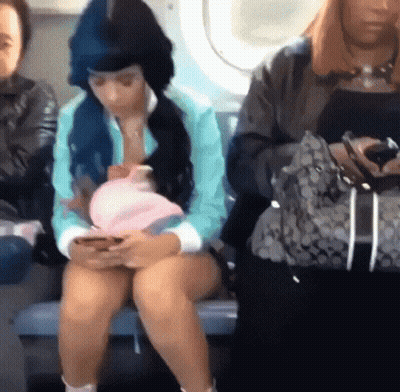 Woman With Blue Hair Sitting On Bus Looking At Phone GIF