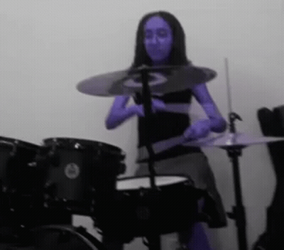 Woman With Blue Paint Playing Drums GIF
