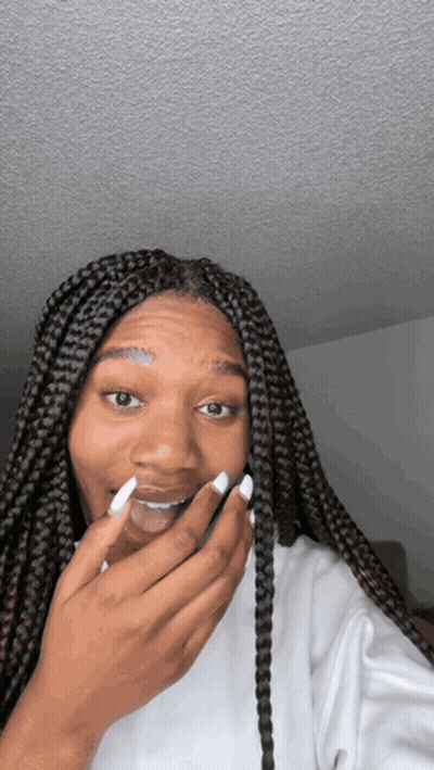 Woman With Braids Covering Mouth GIF