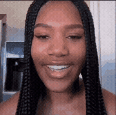 Woman With Braids Smiling In Kitchen GIF