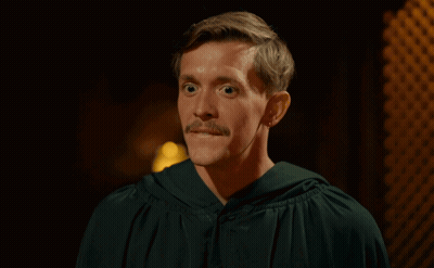 Woman With Bun And Earrings Looking At Camera GIF
