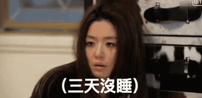 Woman With Bun Sitting In Front Of Suitcase With Chinese Writing GIF