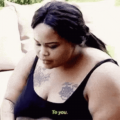 Woman With Chest Tattoo Sitting On Couch GIF