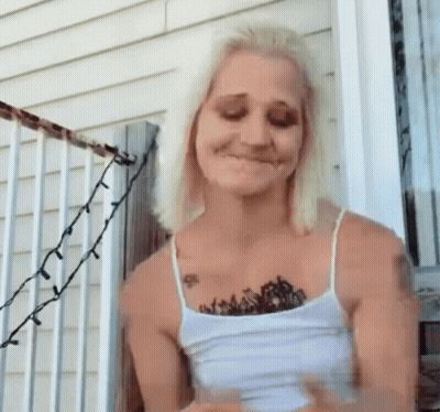 Woman With Chest Tattoo Standing On Porch GIF