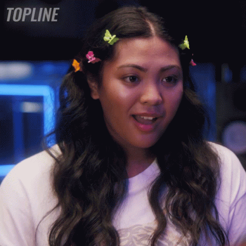 Woman With Colorful Hair Clips Standing In Front Of Topline Sign GIF